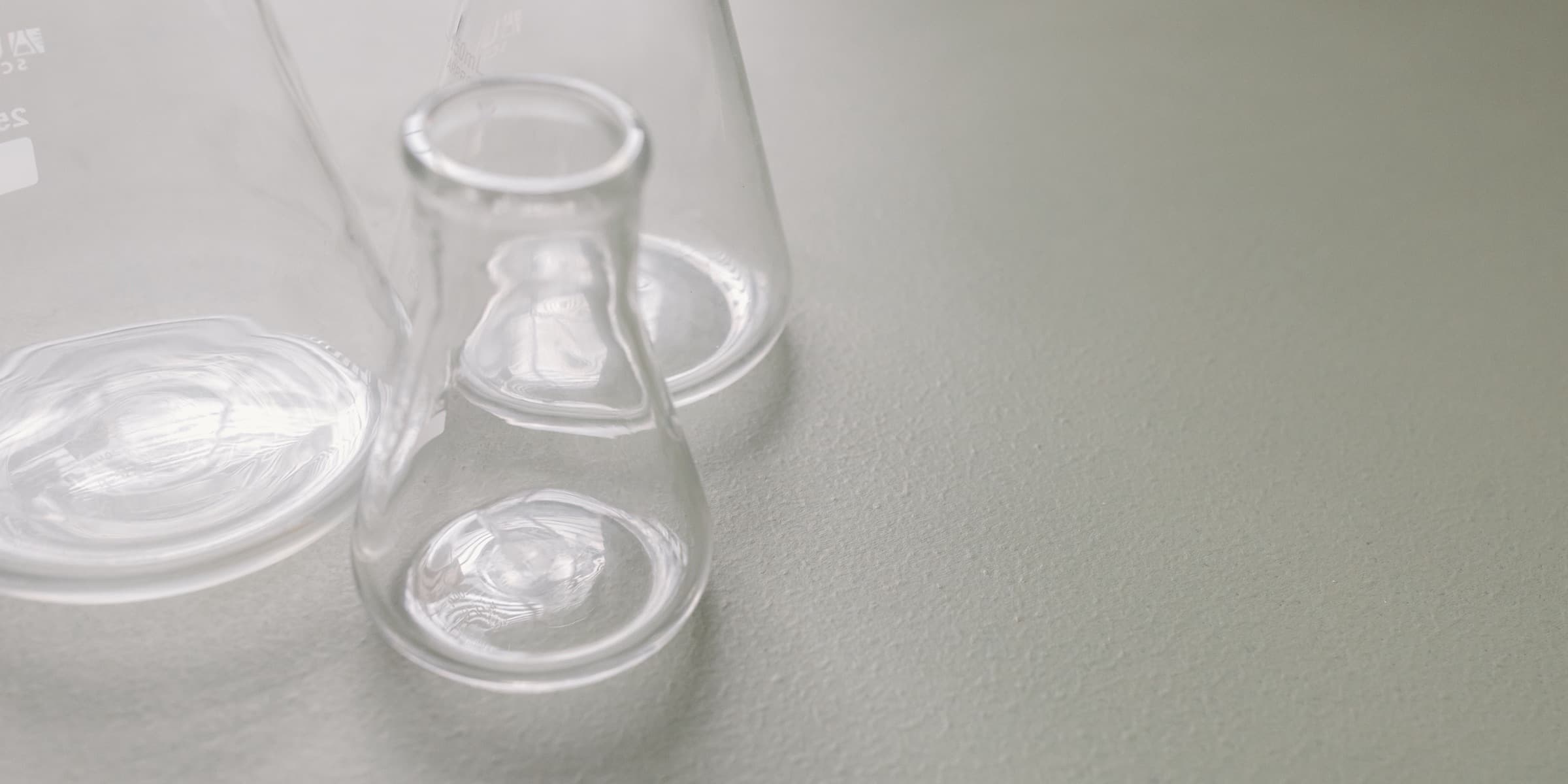 Clear Erlenmeyer flasks on a light surface